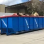 Large roll-off dumpster placed in a residential driveway in Orlando for junk removal.