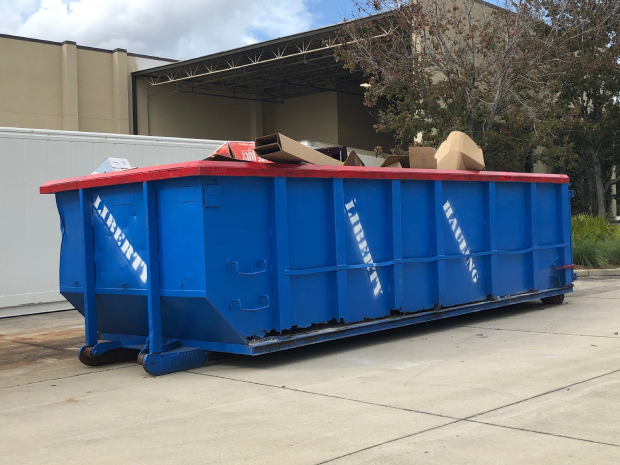 Large roll-off dumpster placed in a residential driveway in Orlando for junk removal.